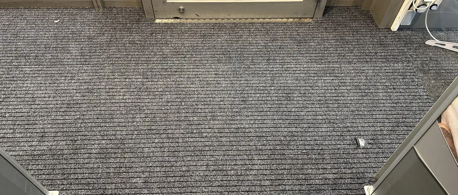 Neue graue Sauberlaufmatte im Eingangsbereich eines Geschäfts, verlegt von MANOVA