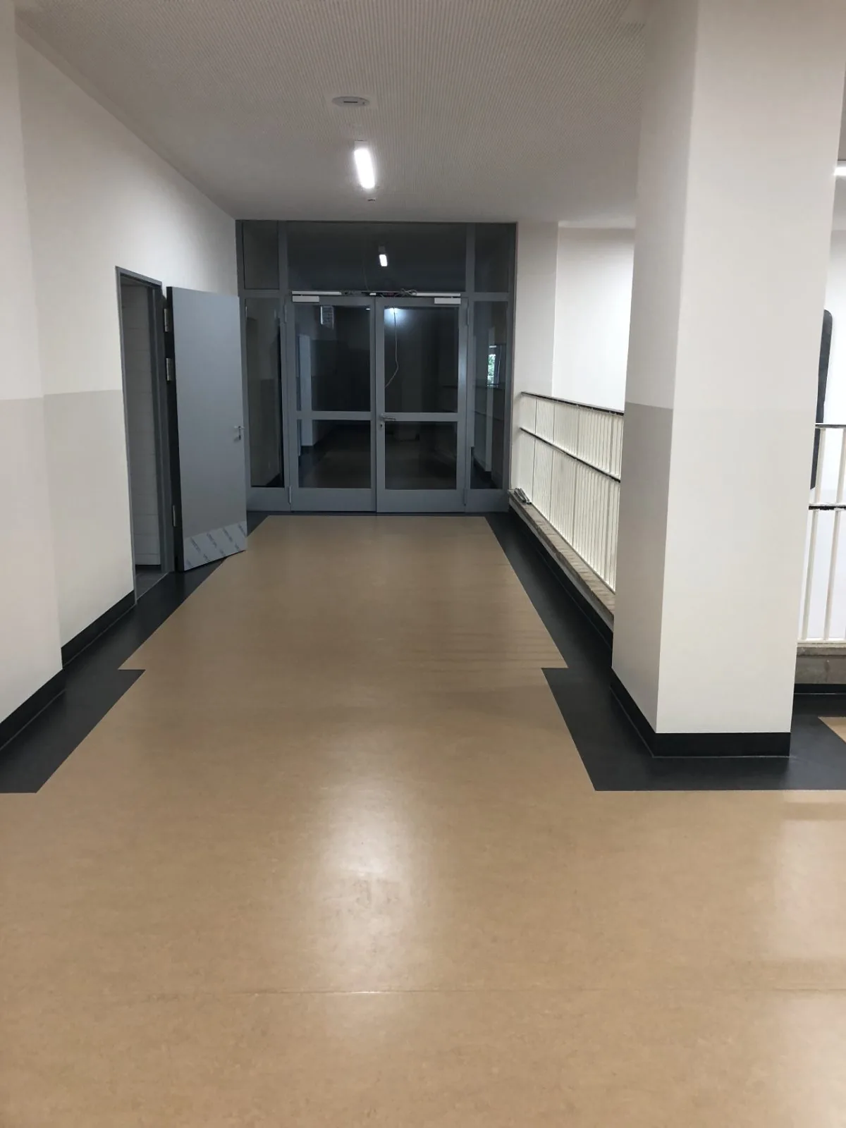 Fertiger Flur mit beigem Bodenbelag und schwarzem Sockel nach dem Ausbau durch MANOVA, Berlin